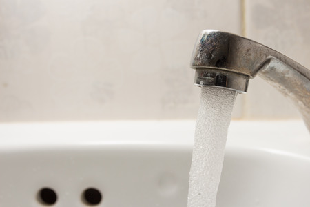 faucet with water drop at bathroom with copy spcae.の写真素材