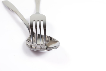 fork stack on spoon on a white background with copy space.の写真素材