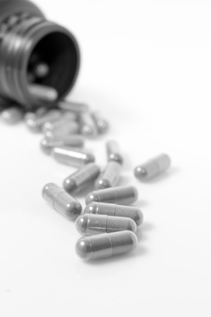 Herbal medicine capsules on white background.Black and white concept.の写真素材