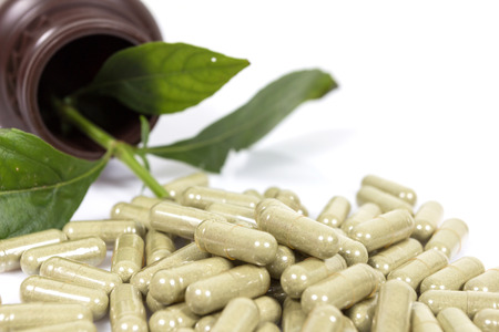 Herbal medicine capsules on white background.の写真素材