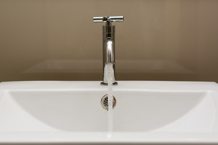 faucet flowing water in the bathroom.の写真素材