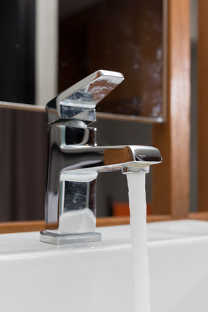 faucet and washbasin with water drop at bathroom.の写真素材