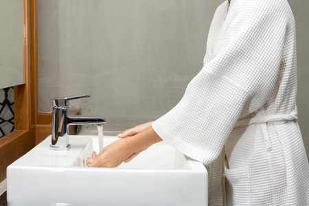 Woman in a bathrobe is washing hands,Hygiene. Cleaning Hands. Washing hands.の写真素材
