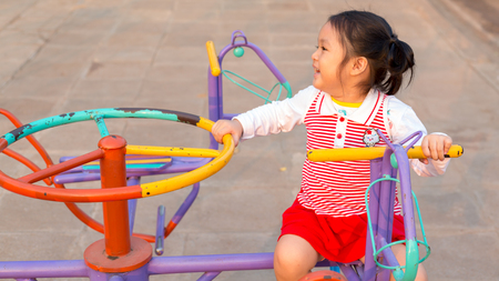 Asian girl is playing on the playgroundの写真素材