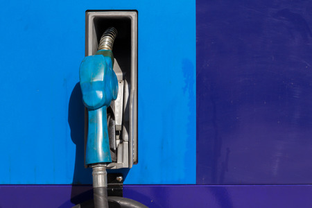 Blue fuel nozzle at a gas station with copy space