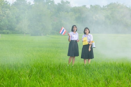 UdonThani, Thailand - Sep. 2, 2016 : Students in Thailand with nature rice fields in the background.のeditorial素材