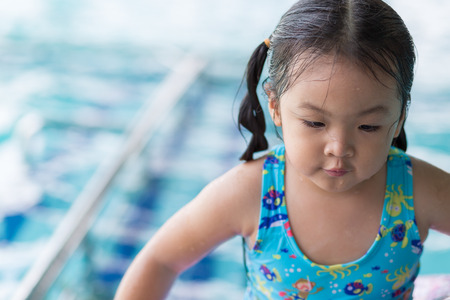 Portraits of Asian girl wearing a swimsuit. Swimming in the pool with copy space.の写真素材