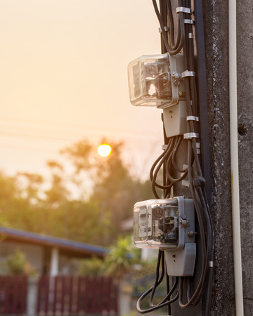 Electric power meter were installed on electricity poles in Thailand with sunset background.の写真素材