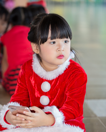 Happy little girl in santa claus costume over christmas.の写真素材