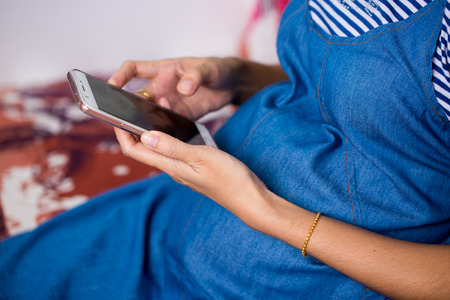 Close up hand of pregnant women using smart phones to search for information about health care.の写真素材
