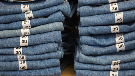 Blue jeans denim Collection jeans stacked with lable size.の写真素材
