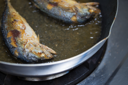 Close up of mackerel fish fried deep oil in pan cooking thai food.の写真素材