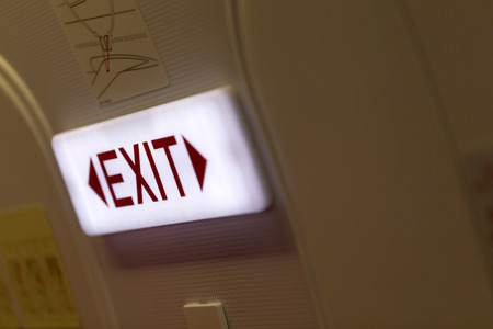 Close up of exit sign in passenger airplaneの写真素材