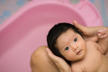 Asian new born having a bath by motherの写真素材