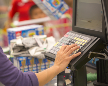 The hands of the cashier are using the cash machine in the mallの写真素材