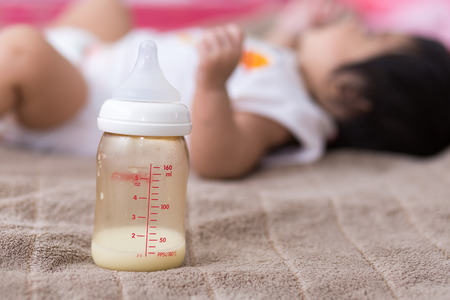 Close up of bottle of milk with infant.の写真素材