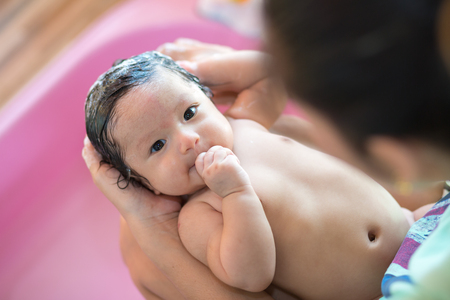 Asian new born having a bath by mother.の写真素材