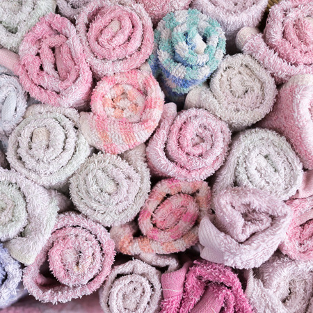 Close up pile of hand towels in wooden basket.