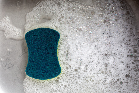 Sponge with bubbles in the sinkの写真素材