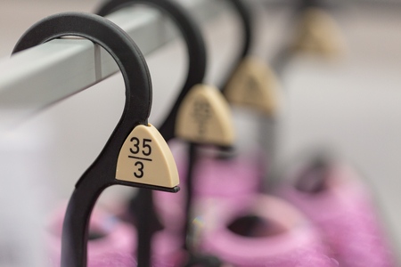 Close up hangers showing different European clothing size tags.の写真素材