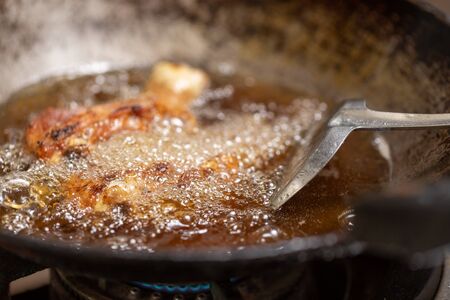 Fried chicken in hot oil and boiling in pan.の写真素材
