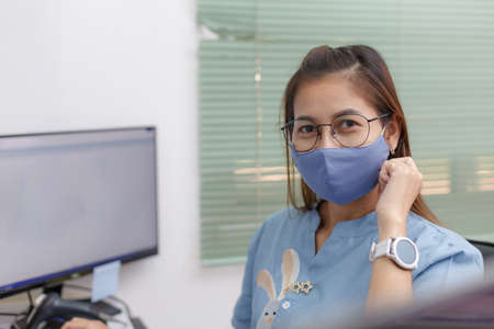 Female employee wears face mask in customer service for measures to prevent virus covid-19