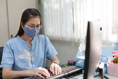 Female employee wears face mask in customer service for measures to prevent virus covid-19の写真素材