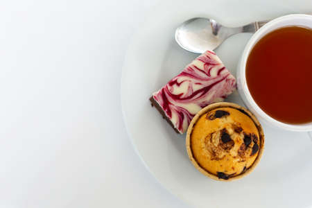 cup of tea with cake on white tablecloth.の写真素材