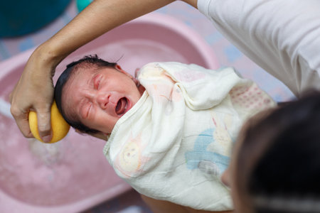 Asian new born having a bath by mother.