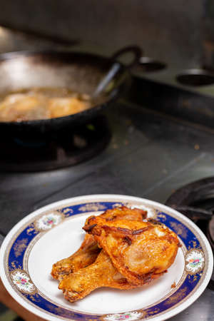 Fried chicken in a plate with a gas stove background.の写真素材
