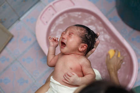 Asian new born having a bath by mother.の写真素材