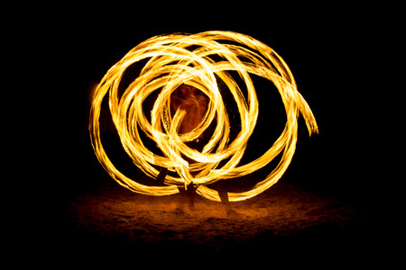 Fire show man in action on the beachの写真素材