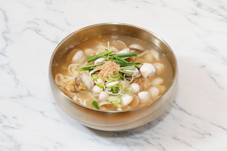 Korean Noodle Soup with Clams on bright background.