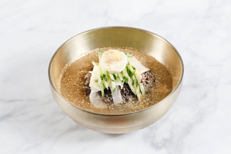 July 8, 2025-Sangju, South Korea-A Various styles Naengmyeon(Buckwheat cool noodles) decorated on the marble table. Naengmyeon or Buckwheat cool noodles is noodle dish of North Korean origin which consists of long and thin handmade noodles made from the flour and starch of various ingredients, including most commonly buckwheat but also potatoes, sweet potatoes, arrowroot starch, and kudzu. Other varieties of naengmyeon are made from ingredients such as seaweed and green tea.の写真素材