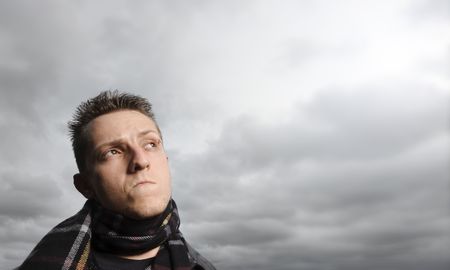 Young man looks up at the clouds aboveの写真素材