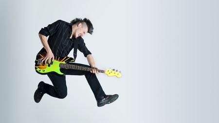 Awesome mohawk man jumps with his guitar in studio