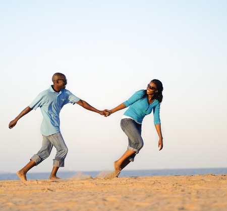 African American couple hand in hand on the beachの写真素材