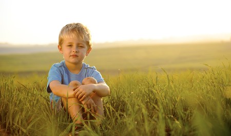 young boy enjoys his time outside in the fieldの写真素材