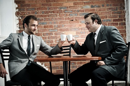 businessmen agree as the cheers with their coffee mugsの写真素材