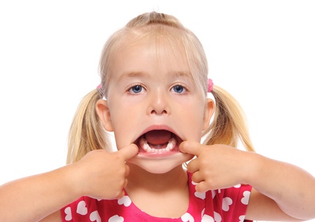 young girl pulls her mouth open and shows teeth 