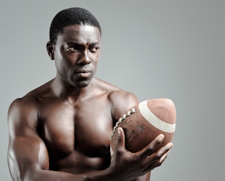 Serious portraits of a black american football sportsman in studio の写真素材