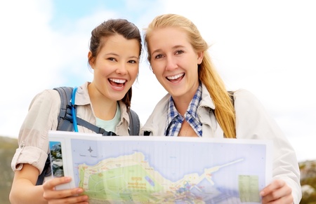 Happy women hold map and laugh. fun outdoor adventure lifestyle concept. 