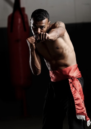dramatic lighting on a martial arts fighter punching in the gymの写真素材