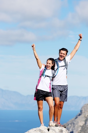 Hiking couple happy to reach the top of a mountain, healthy happy outdoor lifestyleの写真素材