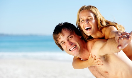 carefree couple embrace and enjoy some summer beach loving on a tropical islandの写真素材