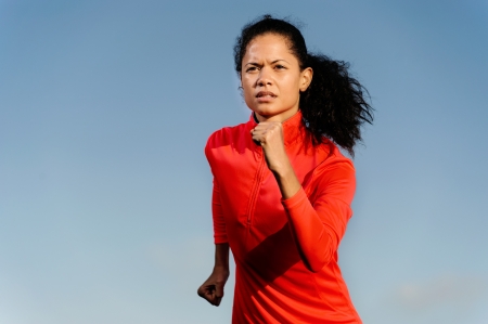 Portrait of an athlete running fitness woman with blue sky copyspace and red jacket. healthy athlete lifestyle.の写真素材