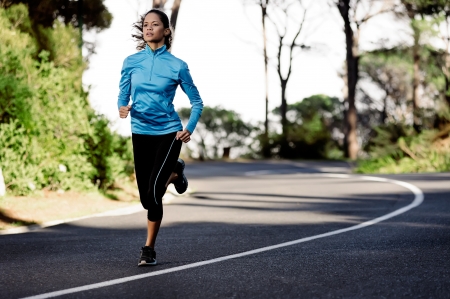 portrait of a healthy woman training for running along a mountain road alone. fitness wellness athleteの写真素材