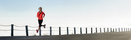 Athletic runner training alone on a road outdoors for marathon and fitness. healthy wellness exercise panorama with copyspace. の写真素材