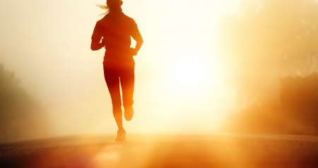 Runner athlete feet running on road  woman fitness silhouette sunrise jog workout wellness concept の写真素材