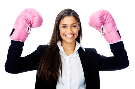 Successful competitive businesswoman is happy and and has boxing gloves while wearing a suit and isolated on white backgroundの写真素材